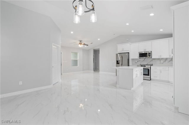 kitchen featuring appliances with stainless steel finishes, open floor plan, white cabinets, and a kitchen island