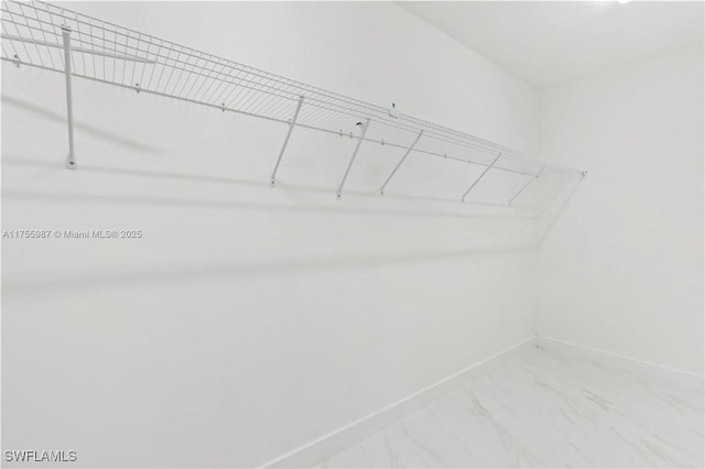 walk in closet with marble finish floor