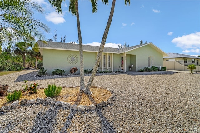 view of front facade featuring fence and stucco siding