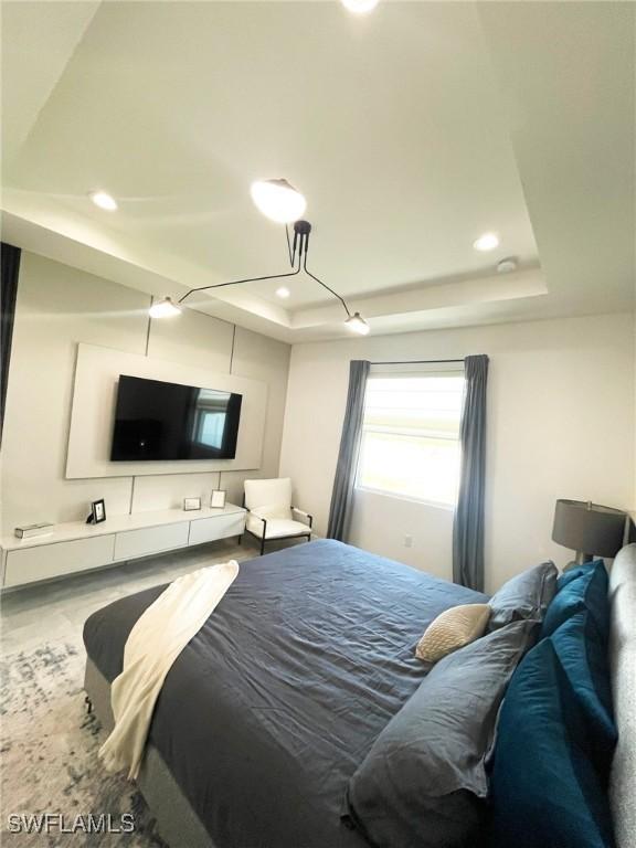 bedroom with recessed lighting and a raised ceiling