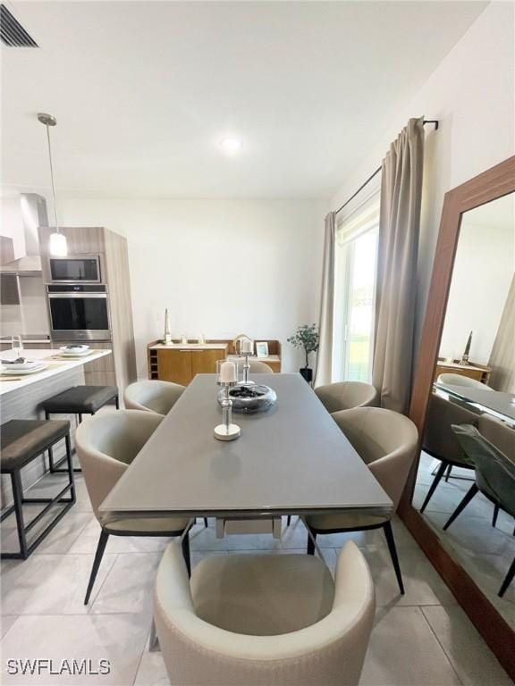 dining area featuring visible vents and light tile patterned flooring