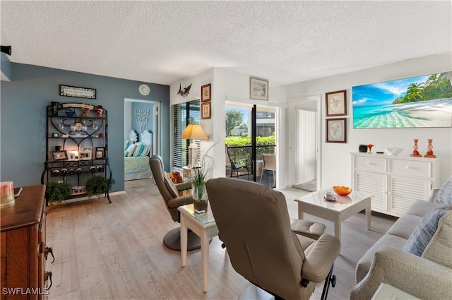 living room featuring light wood-type flooring and a textured ceiling