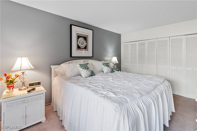 bedroom with a closet and light colored carpet