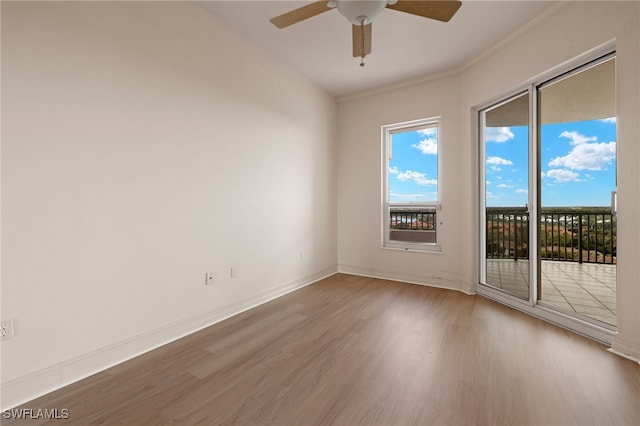 empty room with ceiling fan, baseboards, and wood finished floors