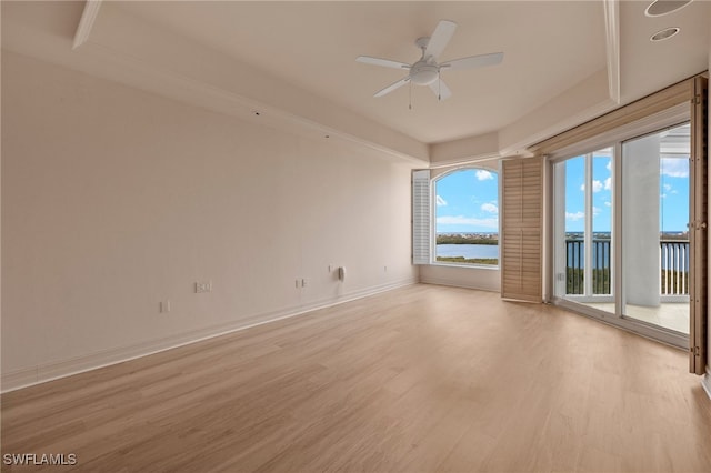 spare room with a ceiling fan, a water view, light wood-style flooring, and baseboards