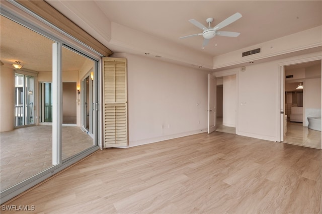 spare room with light wood-style floors, visible vents, baseboards, and a ceiling fan