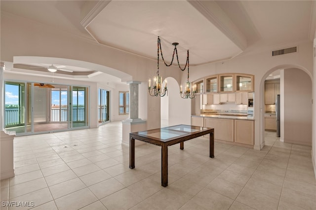 unfurnished dining area with light tile patterned floors, visible vents, arched walkways, a ceiling fan, and a tray ceiling