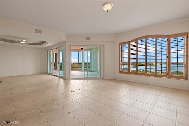 spare room with a ceiling fan, a healthy amount of sunlight, visible vents, and ornamental molding