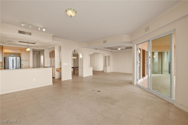 unfurnished room featuring arched walkways, a ceiling fan, baseboards, visible vents, and crown molding