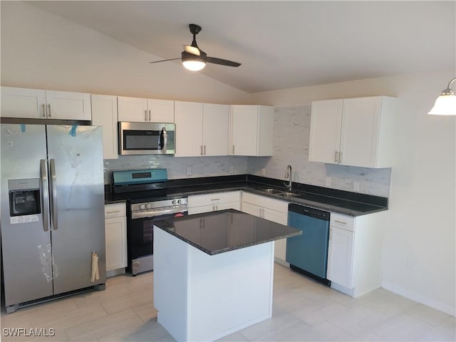 kitchen featuring a sink, white cabinets, appliances with stainless steel finishes, a center island, and dark countertops