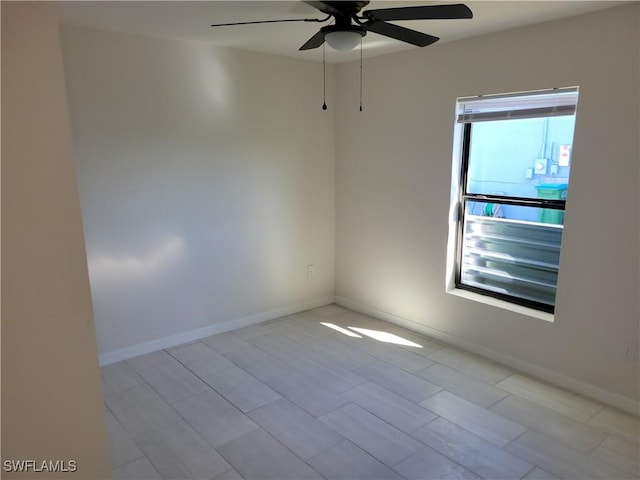 spare room featuring baseboards and a ceiling fan