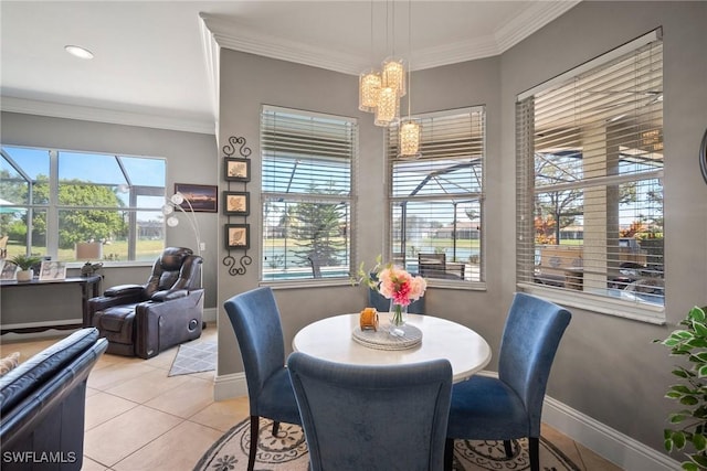 dining space featuring a notable chandelier, crown molding, baseboards, and light tile patterned floors