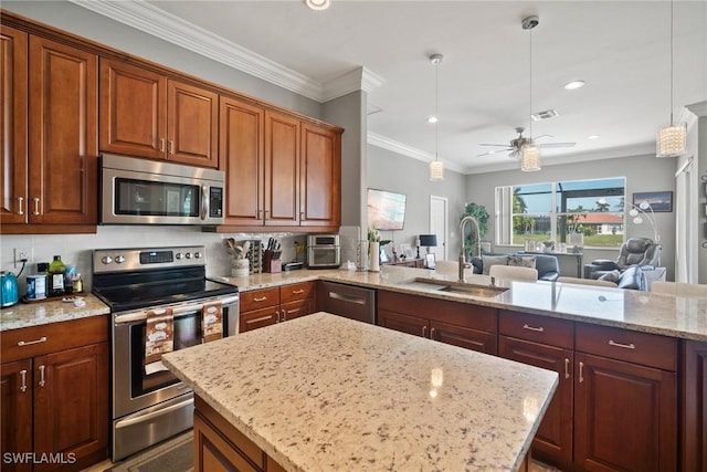 kitchen featuring light stone counters, a sink, open floor plan, appliances with stainless steel finishes, and pendant lighting