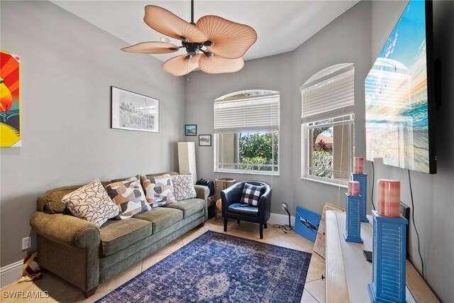 living room with light tile patterned floors, baseboards, and a ceiling fan