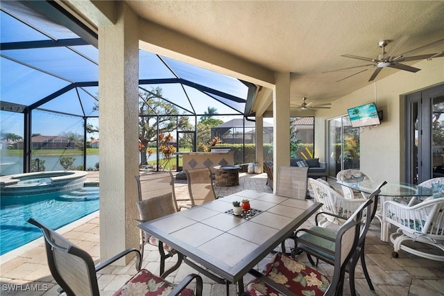 view of patio / terrace featuring glass enclosure, outdoor dining area, a water view, and ceiling fan