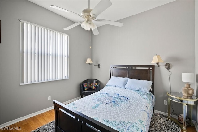 bedroom featuring ceiling fan, baseboards, and wood finished floors