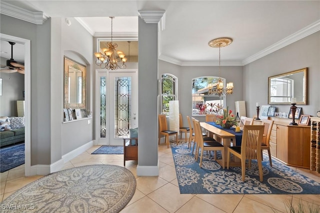 dining room featuring decorative columns, baseboards, ornamental molding, light tile patterned flooring, and ceiling fan with notable chandelier