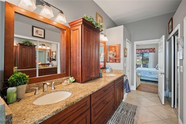 ensuite bathroom featuring tile patterned floors, double vanity, a sink, and ensuite bathroom