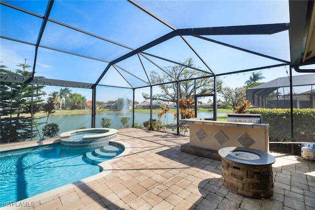 view of swimming pool featuring a patio area, a water view, a fire pit, and an outdoor kitchen