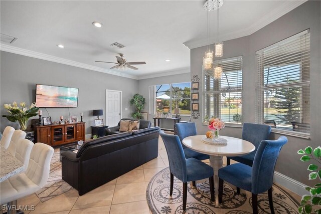 dining space with ornamental molding, a ceiling fan, baseboards, and light tile patterned floors