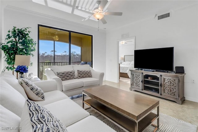 living area featuring a ceiling fan, visible vents, and crown molding