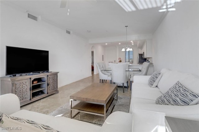 living area featuring arched walkways, visible vents, light tile patterned flooring, and an inviting chandelier