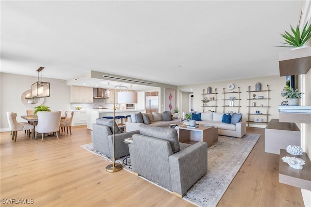 living area with an inviting chandelier and light wood-style floors