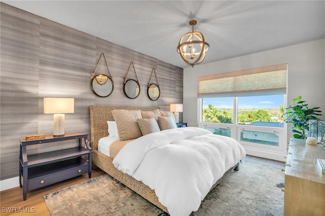 bedroom with a notable chandelier and wood finished floors