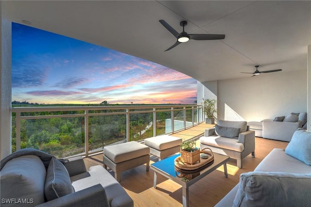 balcony at dusk with an outdoor living space and ceiling fan