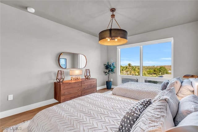 bedroom with baseboards and wood finished floors