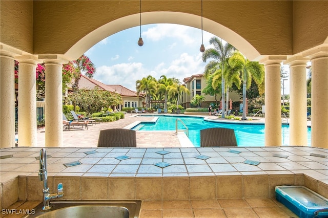 pool featuring a patio and a sink