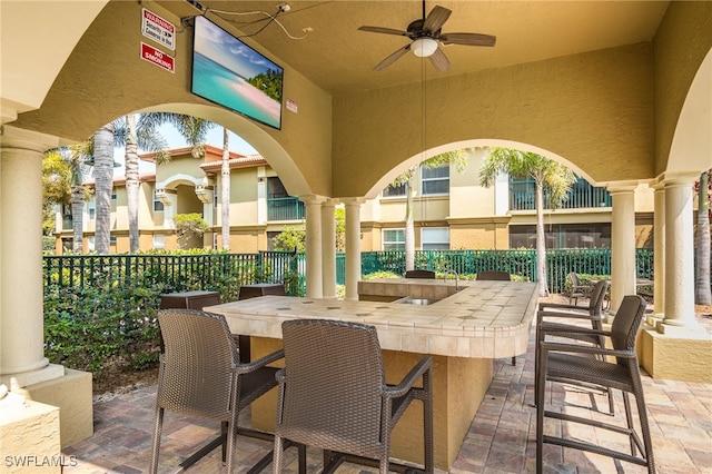 view of patio / terrace with a ceiling fan, fence, and outdoor dry bar