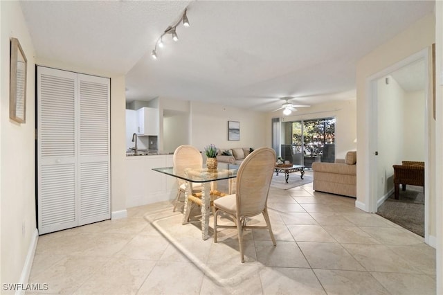 dining space featuring light tile patterned floors, a ceiling fan, and baseboards