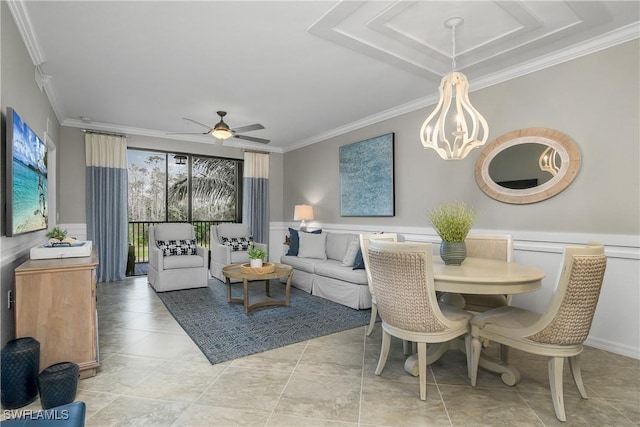 interior space featuring ceiling fan, ornamental molding, and wainscoting