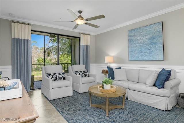 living area featuring ceiling fan, wainscoting, crown molding, and light tile patterned floors