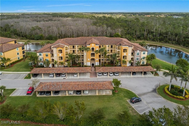 bird's eye view with a water view and a wooded view