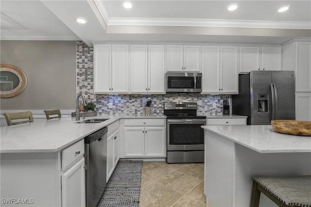 kitchen with stainless steel appliances, a peninsula, a sink, a kitchen breakfast bar, and crown molding