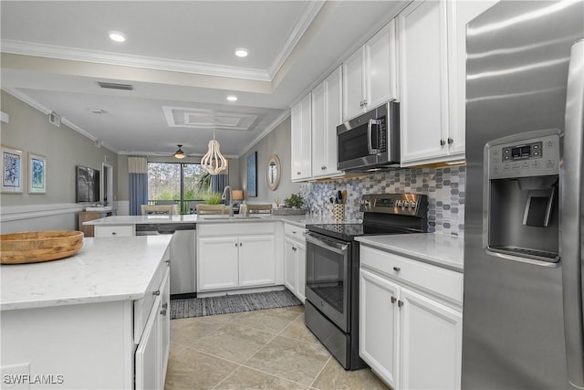 kitchen with stainless steel appliances, a peninsula, a sink, visible vents, and crown molding