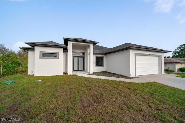 prairie-style house with a garage, a front yard, concrete driveway, and stucco siding