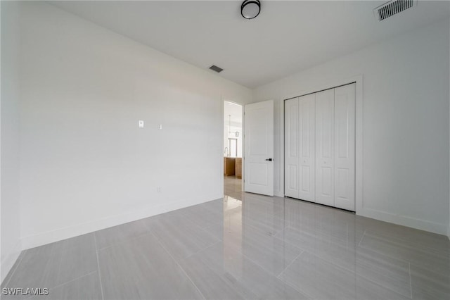 unfurnished bedroom featuring a closet, visible vents, and baseboards