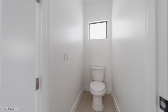 bathroom with toilet, tile patterned flooring, and baseboards