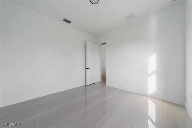 spare room featuring visible vents and baseboards