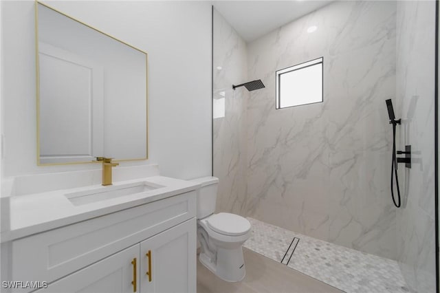 full bath with toilet, a marble finish shower, and vanity