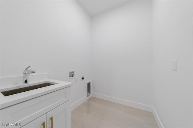 washroom with light tile patterned floors, hookup for a washing machine, hookup for an electric dryer, a sink, and cabinet space