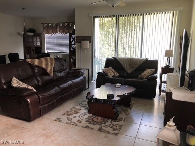 living area featuring ceiling fan and light tile patterned flooring