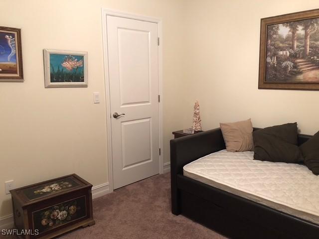 bedroom featuring dark colored carpet and baseboards