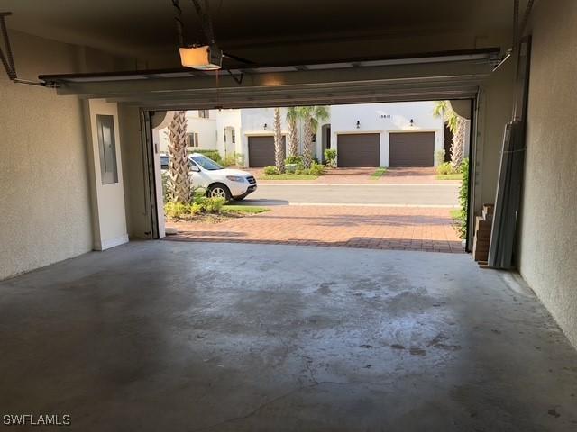 garage with a garage door opener and a textured wall