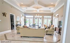 living area featuring a healthy amount of sunlight, a towering ceiling, and ornamental molding