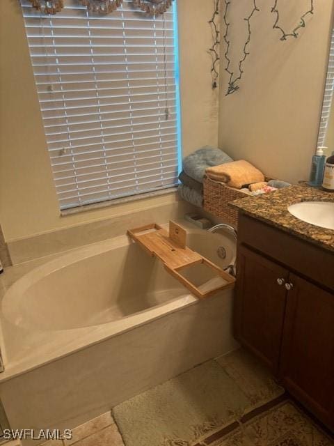 bathroom featuring tile patterned flooring, a bath, and vanity