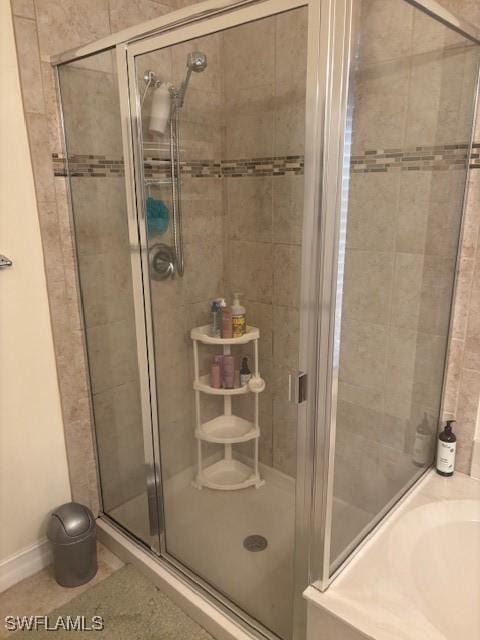 bathroom featuring a shower stall and baseboards